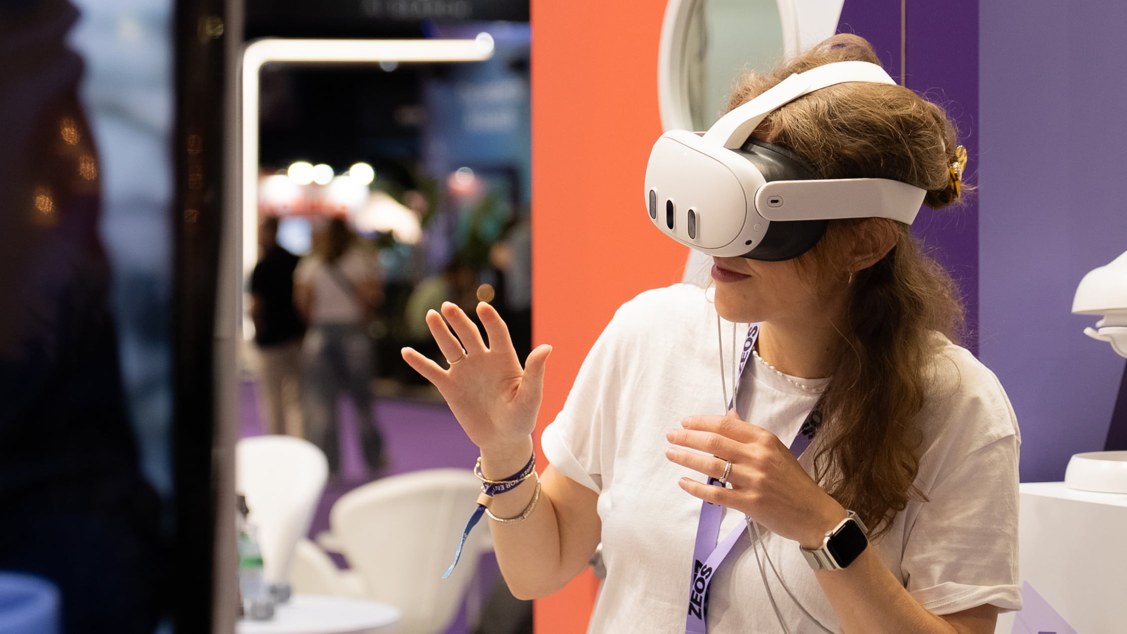 Woman wearing virtual reality headset exploring ZEOS immersive logistics experience at trade fair booth